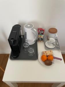 a counter with a coffee maker and a plate of food at Aurelia Rooms in Mostar