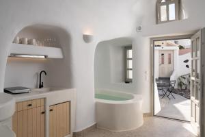 ein Badezimmer mit einer Badewanne und einem Waschbecken in der Unterkunft Nisó Cave Suites in Megalochori