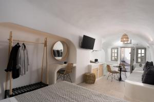 um quarto com uma cama, um lavatório e um espelho em Nisó Cave Suites em Megalochori