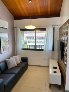 ein Wohnzimmer mit einem Sofa und einem TV in der Unterkunft Duplex Malawí Muro Alto in Porto De Galinhas