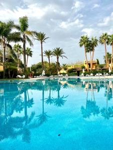 松霍里吉爾的住宿－Casa Pueblo Menorquín 49，一座棕榈树环绕的大型游泳池