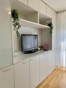 - un salon avec une télévision et des placards blancs dans l'établissement Apartment Nina, à Varaždin