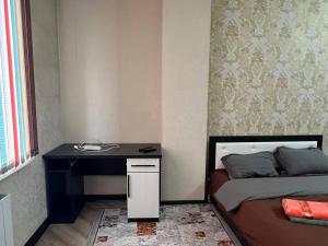 Schlafzimmer mit einem Bett, einem Schreibtisch und einem Schreibtisch in der Unterkunft apartment on Turusbekova 13 in Bischkek