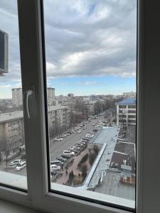 Blick auf einen Parkplatz aus dem Fenster in der Unterkunft apartment on Turusbekova 13 in Bischkek