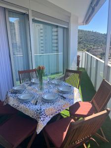 une table avec des assiettes et des verres sur un balcon dans l'établissement Santi Elegance, à La Cala de Finestra