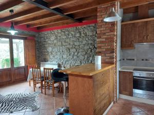 a kitchen and dining room with a table and chairs at La Quintana de Mary in Aramil de Arriba