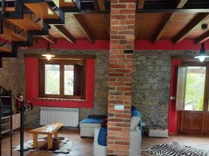 a living room with red walls and wooden ceilings at La Quintana de Mary in Aramil de Arriba