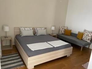 1 dormitorio con 1 cama y 1 sofá en Aurelia Rooms, en Mostar