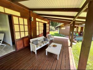 une terrasse couverte d'une maison avec un canapé et une table dans l'établissement Te Fare Manulani, à Uturoa