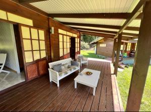 een veranda van een huis met een bank en een tafel bij Te Fare Manulani in Uturoa