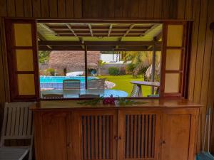 a room with a window with a view of a pool at Te Fare Manulani in Uturoa