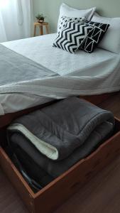einem Bettrahmen aus Holz mit einer Holzkiste unter einem Bett in der Unterkunft HO1016 in Porto Alegre