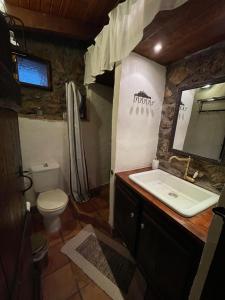 uma casa de banho com um lavatório, um WC e um espelho. em Agoriani Art Studio - Sweet little cottage em Lílaia