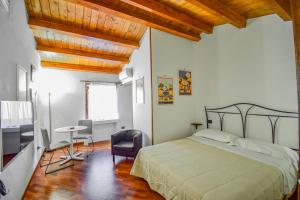 een slaapkamer met een bed en een tafel en stoelen bij Case Ruggero in Cefalù