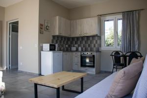 a kitchen with a table and a kitchen with a stove at Casa De Rosa Apartments & Studios in Svoronata