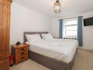 ein Schlafzimmer mit großem Bett und Fenster in der Unterkunft Grants Cottage in Dartmouth