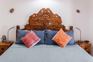 Bett mit einem Kopfteil aus Holz mit Kissen darauf in der Unterkunft Casa Flor de Mayo - fibreoptic internet, dishwasher, washer, dryer & AC in Puerto Morelos + 78 Fotos