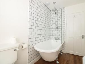 ein weißes Badezimmer mit Badewanne und Toilette in der Unterkunft Grants Cottage in Dartmouth + 17 Fotos