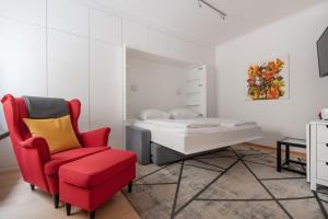 a bedroom with a red chair and a bed at Im Herzen von Wien - Charmante Garconiere in Vienna