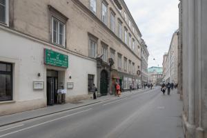 una calle de ciudad vacía con edificios y gente caminando por la calle en Im Herzen von Wien - Charmante Garconiere, en Viena