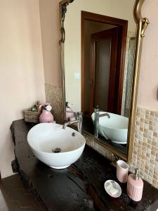 ein Badezimmer mit einem Waschbecken und einem großen Spiegel in der Unterkunft GABRY GUEST HOUSE in Bruno