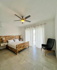 una camera con letto, ventilatore a soffitto e sedia di Residencial Paraiso Bayahibe a Bayahibe Altre 16 foto