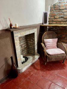 una silla en una habitación con chimenea de ladrillo en GABRY GUEST HOUSE, en Bruno