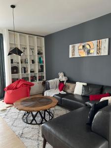 a living room with a black couch and a table at Modern apartment in Skopje in Skopje