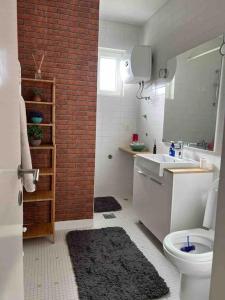 a bathroom with a toilet and a sink and a brick wall at Modern apartment in Skopje in Skopje