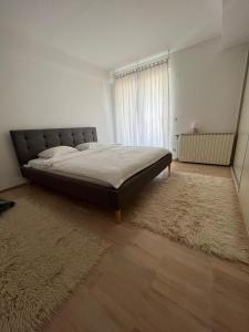 a bedroom with a bed with a rug and a window at Modern apartment in Skopje in Skopje