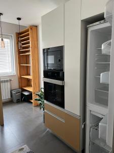 a kitchen with a refrigerator with a tv on it at Modern apartment in Skopje in Skopje