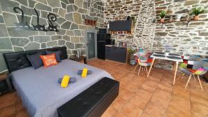 1 dormitorio con cama y pared de piedra en ART STUDIO CENTER, en Kavala