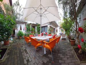 un patio con mesa, sillas y sombrilla en Guesthouse Hygge en Tirana