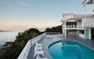 a house with a swimming pool next to the ocean at Bay House Grenada in Belmont