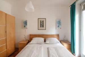 sypialnia z dużym łóżkiem z białą pościelą w obiekcie Im Herzen von Wien w Wiedniu