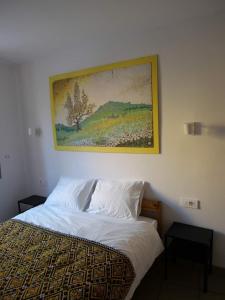 a bedroom with a bed with a painting on the wall at Apartma Drev in Bošnjak in Dobrna