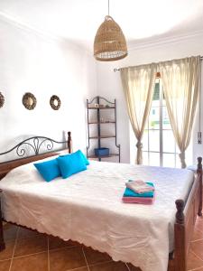a bedroom with a large bed with blue pillows at Sweet Home of Cabanas in Conceição