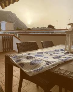 a table with a quilt on top of a balcony at Cala Holidays vicino Aeroporto&Mare in Carini