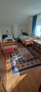 a living room with two beds and a rug at Cottage in traditional village Bradulet, Arges county in Brăduleţ