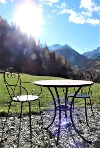 a table and two chairs in a field with the sun at Anniviers : studio avec mezzanine in Vissoie
