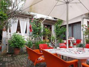 un patio al aire libre con mesas, sillas y plantas en Guesthouse Hygge en Tirana