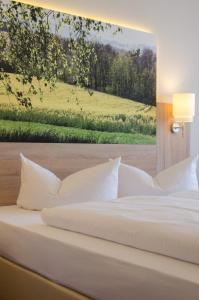 a white bed with a painting on the wall at Garden Hotel in Nürnberg