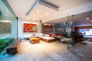 a living room with a couch and a glass wall at BLAZE Hotel & Suites Puerto Vallarta in Puerto Vallarta