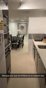 cocina y comedor con mesa y sillas en Appartement CANNES, vue mer triples exposition, en Cannes