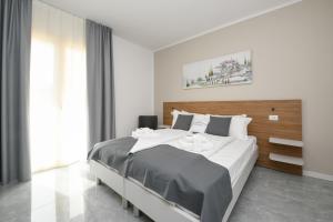 ein Schlafzimmer mit einem großen Bett und einem großen Fenster in der Unterkunft Ranalli Palace in Peschiera del Garda