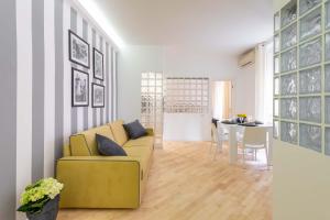 uma sala de estar com um sofá amarelo e uma mesa em VRhome em Roma mais 1 fotografia