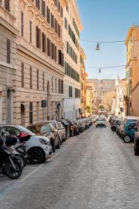 uma rua da cidade com carros estacionados nos lados da estrada em VRhome em Roma