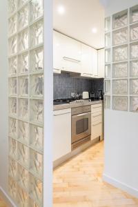 uma cozinha com armários brancos e uma adega de vinhos em vidro em VRhome em Roma