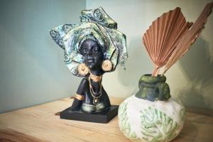 a statue of a woman sitting on a table next to a vase at Alanya City Tower sea&mountain view in Alanya