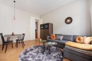 ein Wohnzimmer mit einem Sofa und einem Tisch in der Unterkunft Hochwertiges Apartment mit direkter Anbindung zum Zentrum in hippen Viertel in Wien